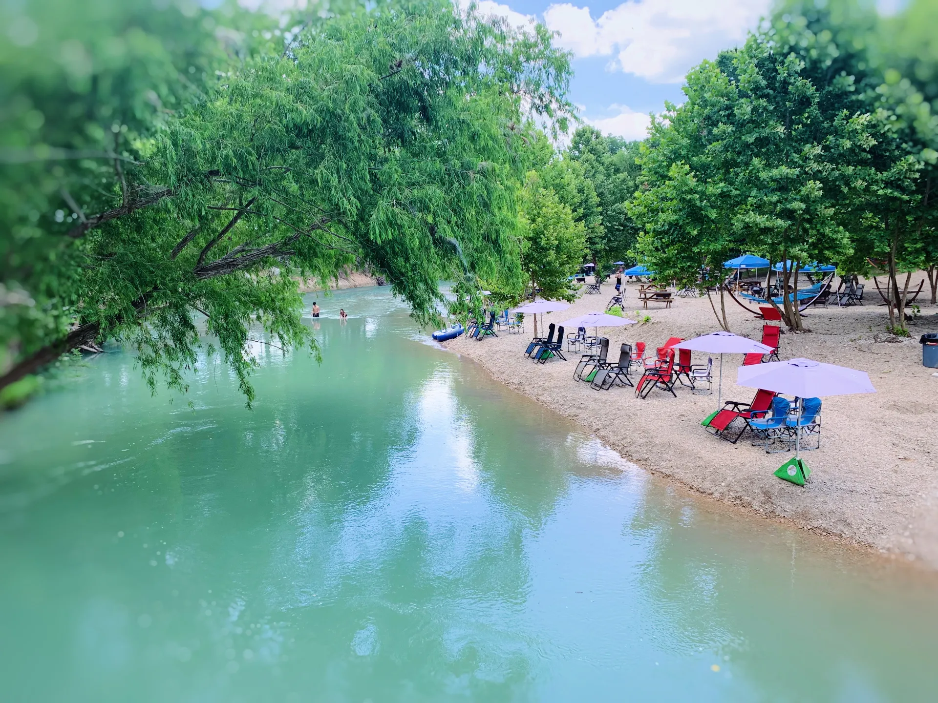 Private river access with calm blue water at Son's Blue River Camp