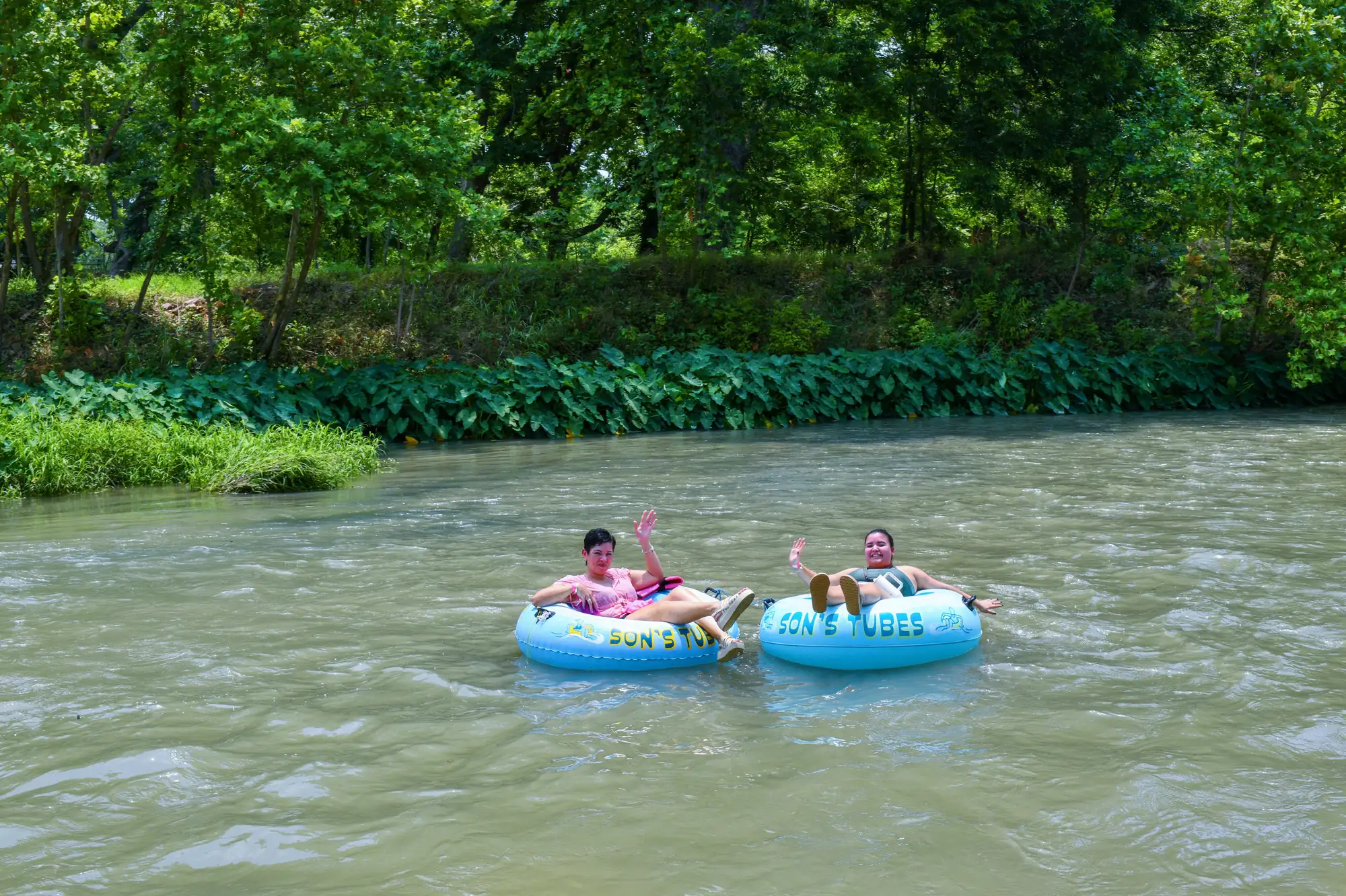 Pair waving while tubing near Austin